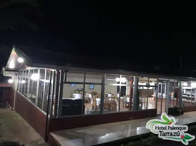 a restaurant at night with a lot of windows at Hotel Palenque Tarrazu in San Marcos