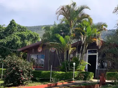 a house with palm trees in front of it at Hotel Palenque Tarrazu in San Marcos