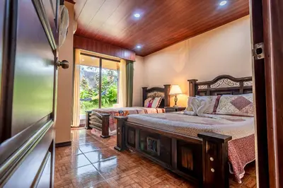 a bedroom with two beds and a window at Aunty Arenal Lodge in Fortuna