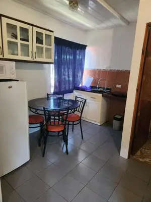 a kitchen with a table and chairs and a kitchen with a refrigerator at Hotel Villa Prats in Manuel Antonio