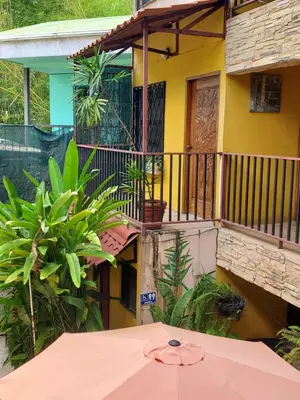 an umbrella sitting in front of a house at Hotel Villa Prats in Manuel Antonio