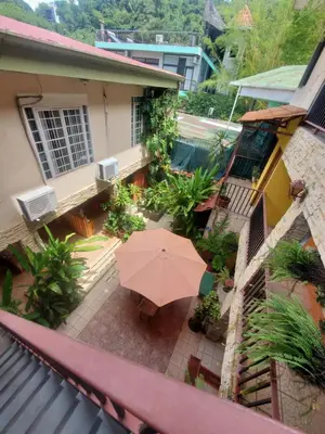 a patio with an umbrella in front of a house at Hotel Villa Prats in Manuel Antonio