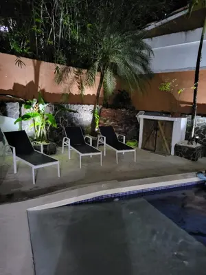 a group of chairs sitting next to a swimming pool at Hotel Villa Prats in Manuel Antonio