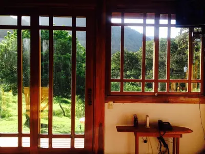 a room with three windows and a table with a view at Lemon House Monteverde in Monteverde Costa Rica