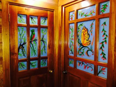 two doors with stained glass windows with a butterfly on them at Lemon House Monteverde in Monteverde Costa Rica