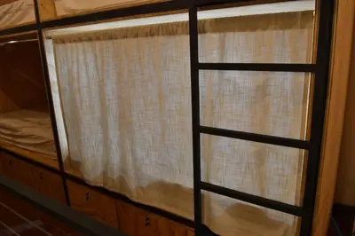 a window with a curtain in a bedroom at Capital Hostel de Ciudad in San José