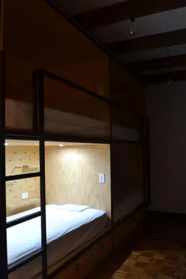a bedroom with two bunk beds with white sheets at Capital Hostel de Ciudad in San José