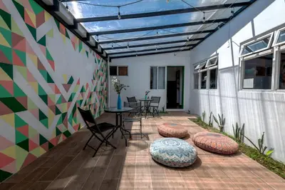 a patio with chairs and a table and a building at Capital Hostel de Ciudad in San José