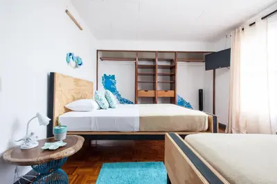 a bedroom with two beds and a table at Capital Hostel de Ciudad in San José