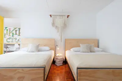 two beds sitting next to each other in a room at Capital Hostel de Ciudad in San José