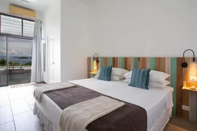a bedroom with a large bed with a view of the ocean at Pura Vista Hotel in Ocotal