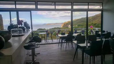 a restaurant with a bar with a view of the ocean at Pura Vista Hotel in Ocotal
