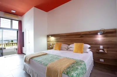a bedroom with a large bed with a wooden headboard at Pura Vista Hotel in Ocotal