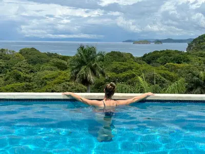 a woman in a swimming pool looking out at the ocean at Pura Vista Hotel in Ocotal