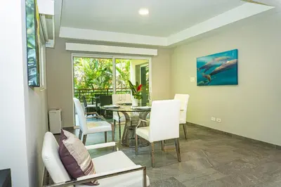 a living room with a table and chairs at Elan at Ballena Beach in Uvita