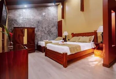 a bedroom with two beds and a dresser in it at Hotel Villa Florencia in Turrialba
