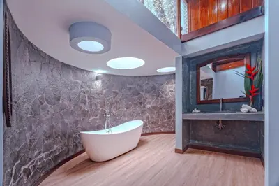 a bathroom with a white tub and a sink at Hotel Villa Florencia in Turrialba
