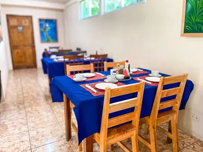 a long blue table with chairs and plates on it at La Casa de la Montaña in Monteverde Costa Rica