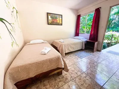 a room with two beds and a window at La Casa de la Montaña in Monteverde Costa Rica