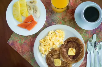 a table with two plates of breakfast food and a cup of coffee at La Casa de la Montaña in Monteverde Costa Rica
