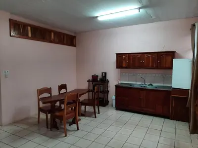 a kitchen with a table and chairs and a sink at Arenal Xilopalo in Fortuna