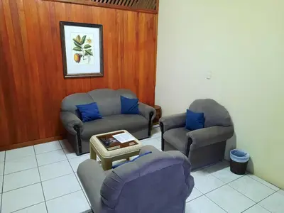 a living room with two chairs and a couch and a table at Arenal Xilopalo in Fortuna