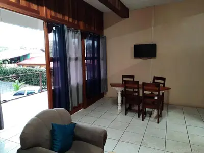 a living room with a table and chairs and a couch at Arenal Xilopalo in Fortuna