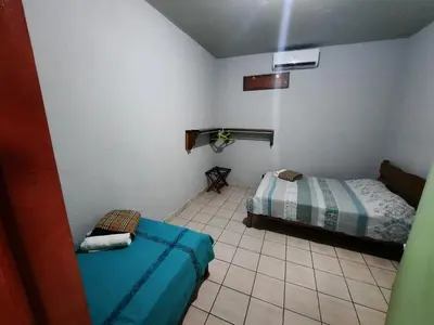 a bedroom with two beds and a tiled floor at Arenal Xilopalo in Fortuna