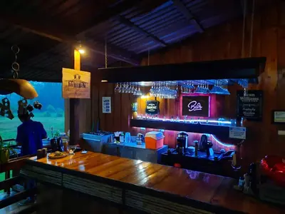 a bar in a restaurant with a wooden counter at Arenal Xilopalo in Fortuna