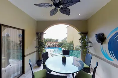 a room with a table and chairs on a balcony at Sunrise 22 in Tamarindo
