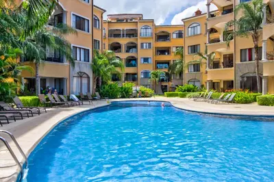 a swimming pool in front of some apartment buildings at Sunrise 22 in Tamarindo