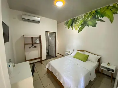 a bedroom with a bed with a green pillow at Ukinca in Uvita