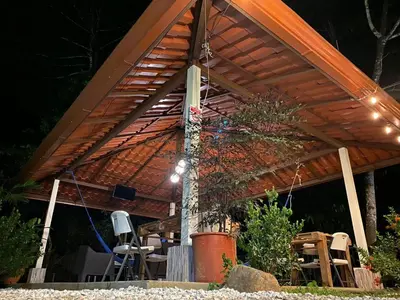a wooden pergola with a table and chairs under it at Ukinca in Uvita