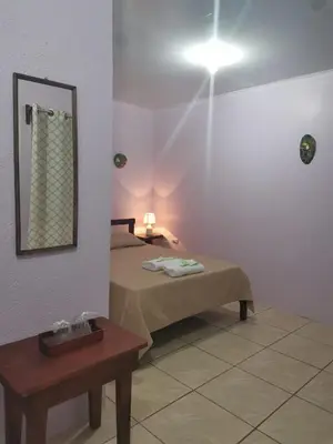 a room with a bed and a mirror and a table at Posada Rural Oasis in Caño Negro