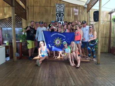 a group of people posing for a picture holding a flag at Vida Hermosa in Playa Hermosa