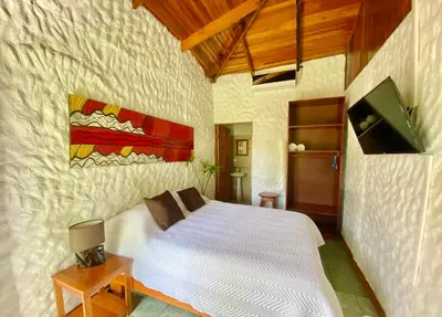 a bedroom with a white bed and a tv at Vida Hermosa in Playa Hermosa