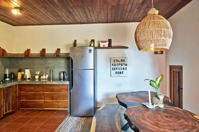a kitchen with a stainless steel refrigerator and a table at Casa Calocita in Santa Teresa Beach