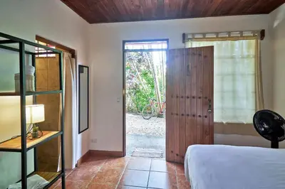 a bedroom with a bed and a sliding glass door at Casa Calocita in Santa Teresa Beach