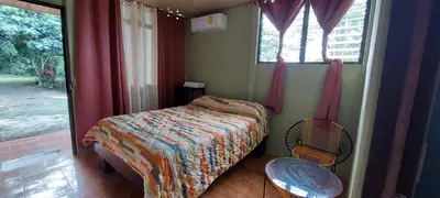 a small bedroom with a bed and a window at Hostal y cabinas anita-and rafting tour! in Siquirres