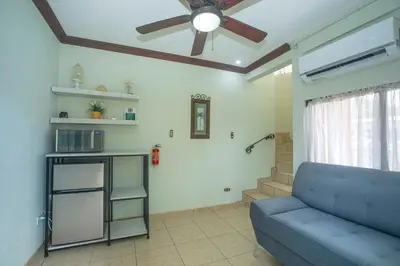 a living room with a blue couch and a ceiling fan at Green Villas El Coco in Coco