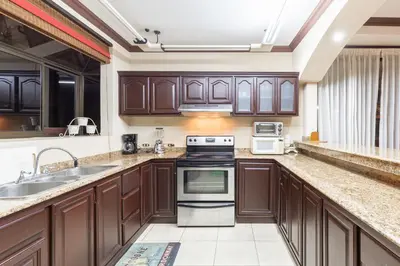 a large kitchen with wooden cabinets and appliances at Green Villas El Coco in Coco