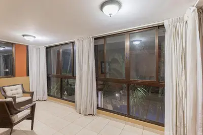 a living room with large glass windows and a chair at Green Villas El Coco in Coco