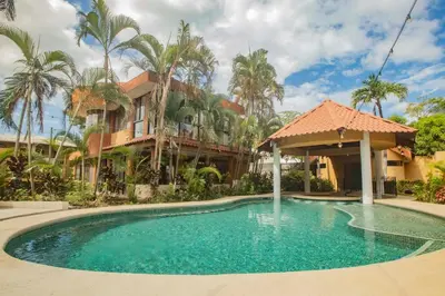 a swimming pool in front of a house with palm trees at Green Villas El Coco in Coco