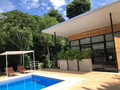 a swimming pool in front of a house at Rancho Capulin B&B in Tarcoles