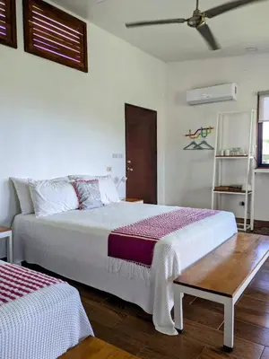 a bedroom with two beds and a table at Rancho Capulin B&B in Tarcoles