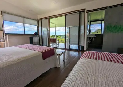 a hotel room with two beds and a balcony at Rancho Capulin B&B in Tarcoles