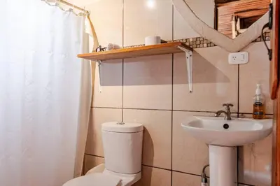 a small bathroom with a toilet and a sink at Monteverde Romantic Cabañas 5minutes mtv park in Monteverde Costa Rica