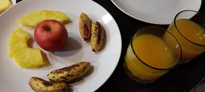 a plate of fruit and a glass of orange juice at Monteverde Romantic Cabañas 5minutes mtv park in Monteverde Costa Rica