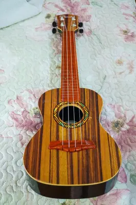 a wooden guitar sitting on top of a blanket at Monteverde Romantic Cabañas 5minutes mtv park in Monteverde Costa Rica