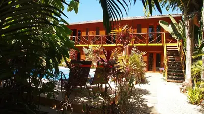 a resort building with a staircase and plants in front of it at Samara Palm Lodge in Sámara